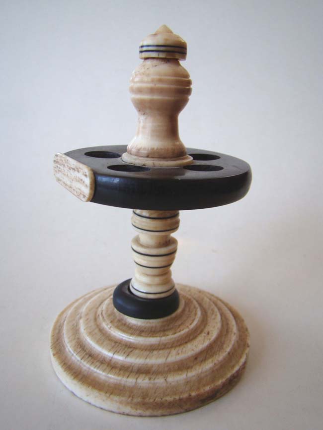 A late 19th century whalebone stand holding five fids.